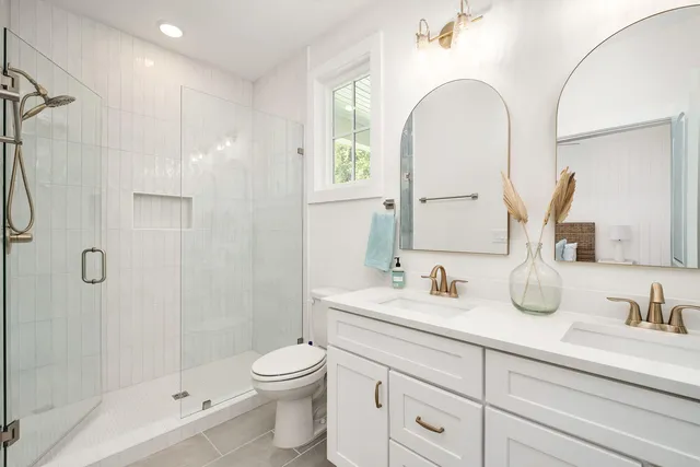 a bathroom with a double vanity sink toilet and shower