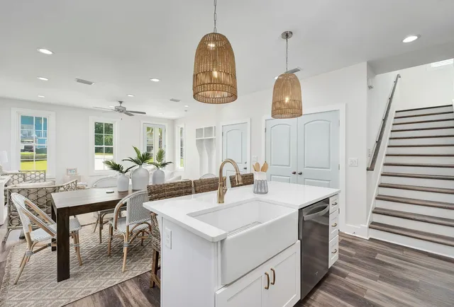 a room with stainless steel appliances kitchen island a table and chairs in it