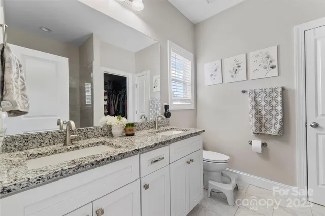 a bathroom with a granite countertop sink mirror vanity and toilet