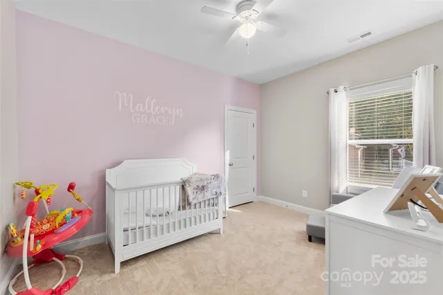 a bedroom with a baby bed a couch and a baby crib