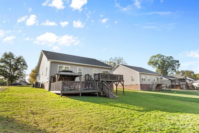 a view of a house with a big yard potted plants and large tree
