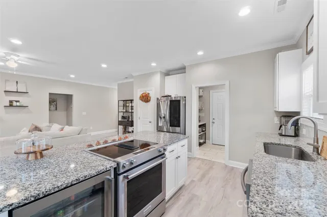 a kitchen with stainless steel appliances granite countertop a sink stove and refrigerator