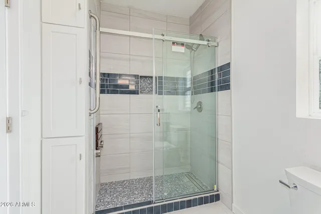 an empty room with closet and windows