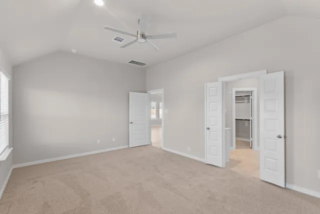 an empty room with a ceiling fan and a window