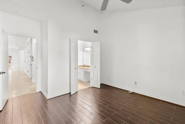 a view of a room with wooden floor and a bathroom