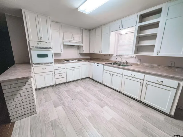 a kitchen with granite countertop white cabinets and white appliances