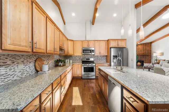 a kitchen with stainless steel appliances granite countertop white cabinets a microwave oven a sink and dishwasher with wooden floor