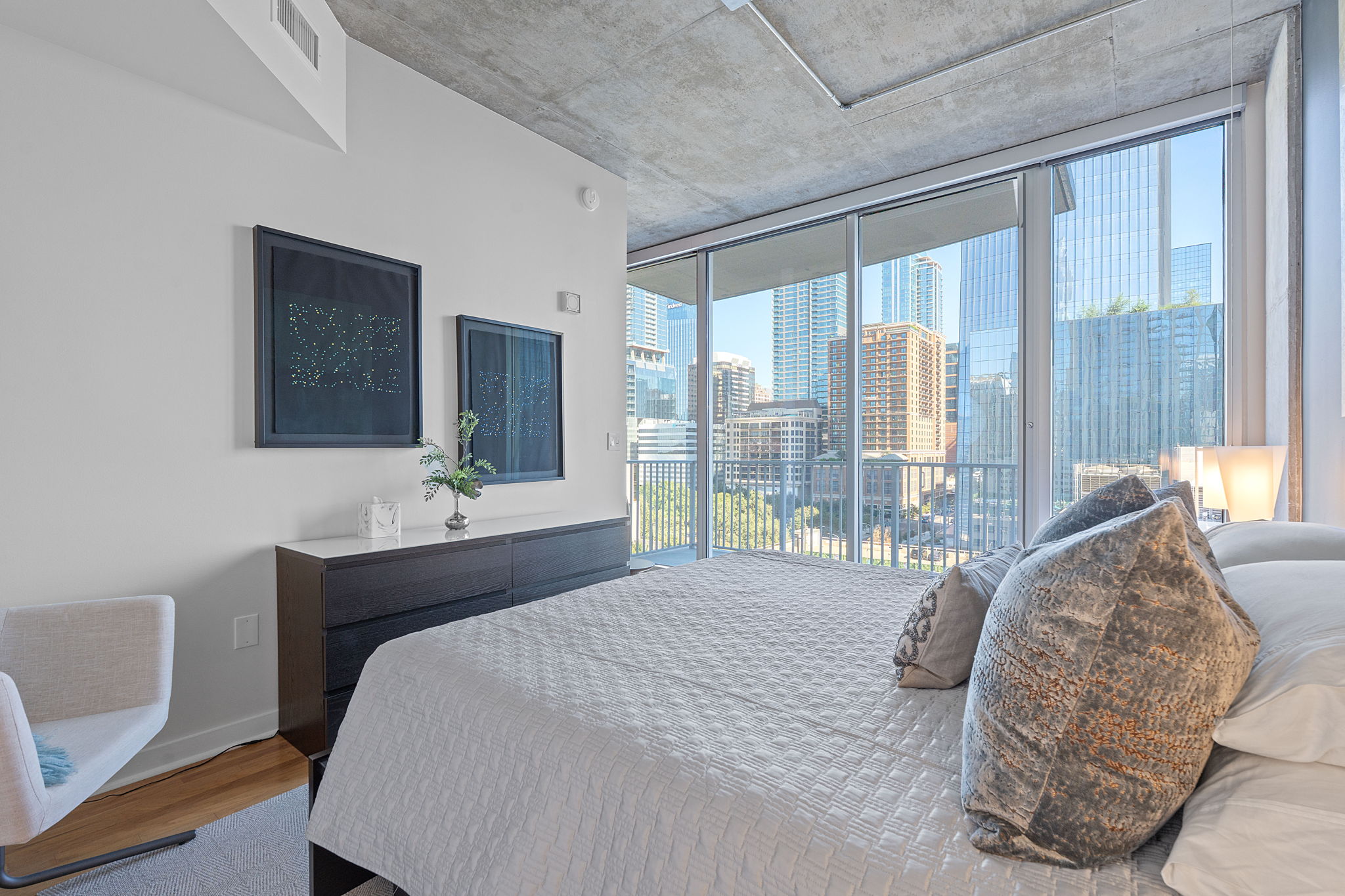 360 Nueces Street, Unit 1007 Austin, TX 78701 - Photo 17 of 40 Bedroom featuring a view of skyline, wood finished floors, access to exterior, and expansive windows
