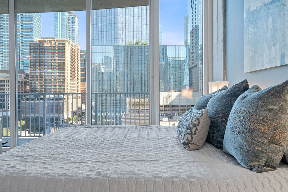 360 Nueces Street, Unit 1007 Austin, TX 78701 - Photo 18 of 40 a bed sitting in a bedroom next to a window