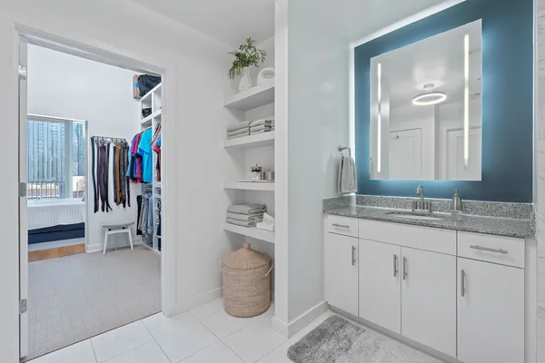 a en suite bathroom with a granite countertop sink and a mirror