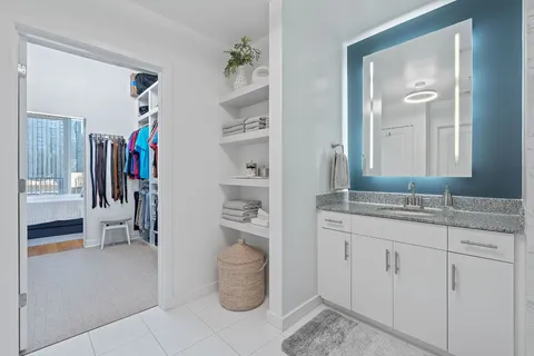 a en suite bathroom with a granite countertop sink and a mirror