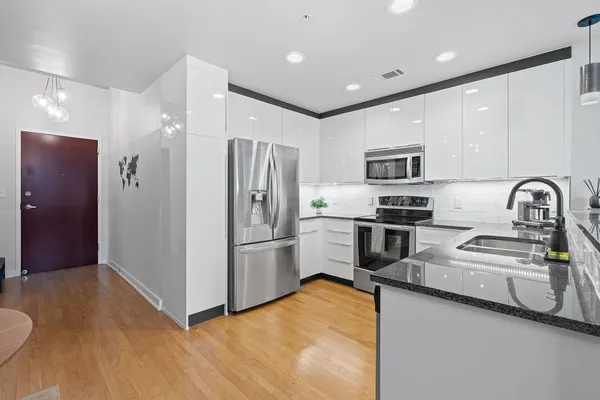 a kitchen with stainless steel appliances a refrigerator and a stove top oven