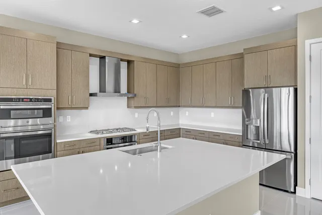 a kitchen with granite countertop a refrigerator and a sink