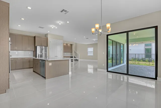 a view of a kitchen with granite countertop a large counter top a stove and a chandelier