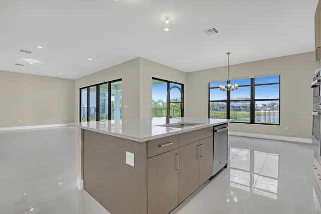 a large white kitchen with granite countertop a large window