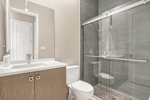 a bathroom with a sink a toilet and shower