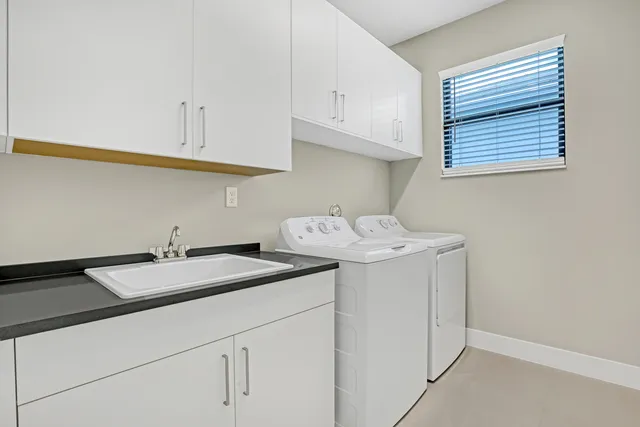 a utility room with sink dryer and washer