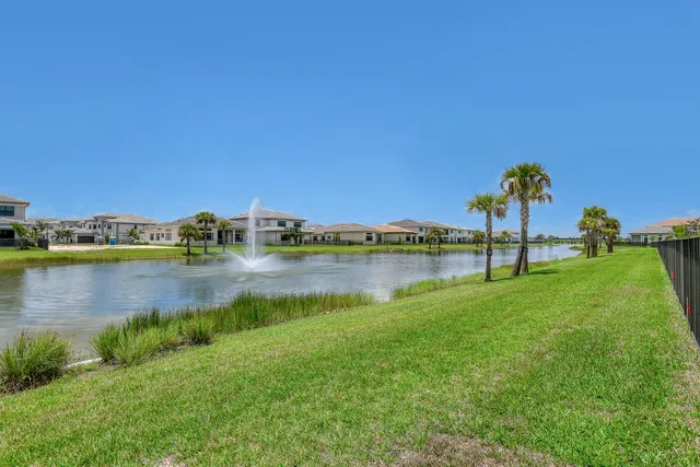 a view of a lake with a big yard and large trees