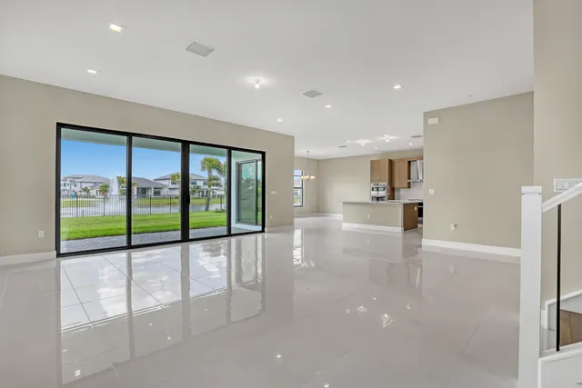 a view of empty room with wooden floor and floor to ceiling window