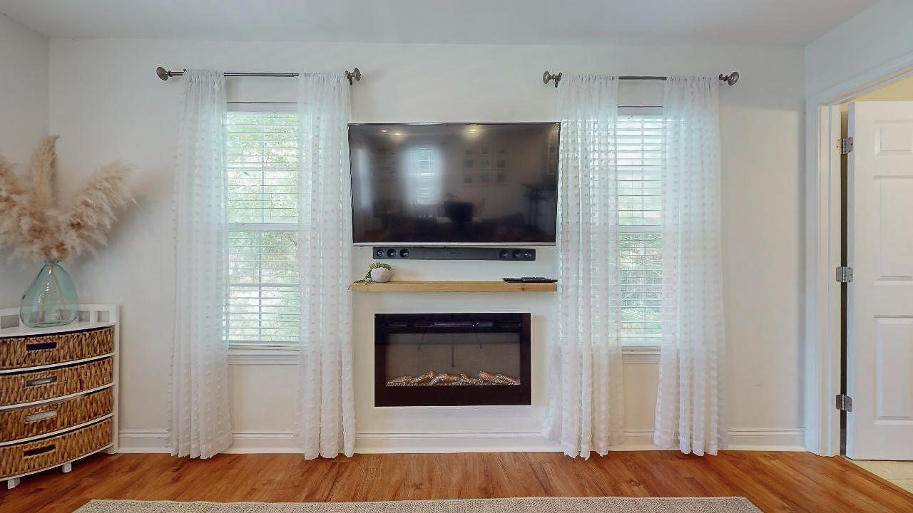2623 Bay Grove Road Freeport, FL 32439 - Photo 8 of 56 a living room with furniture a flat screen tv and a fireplace