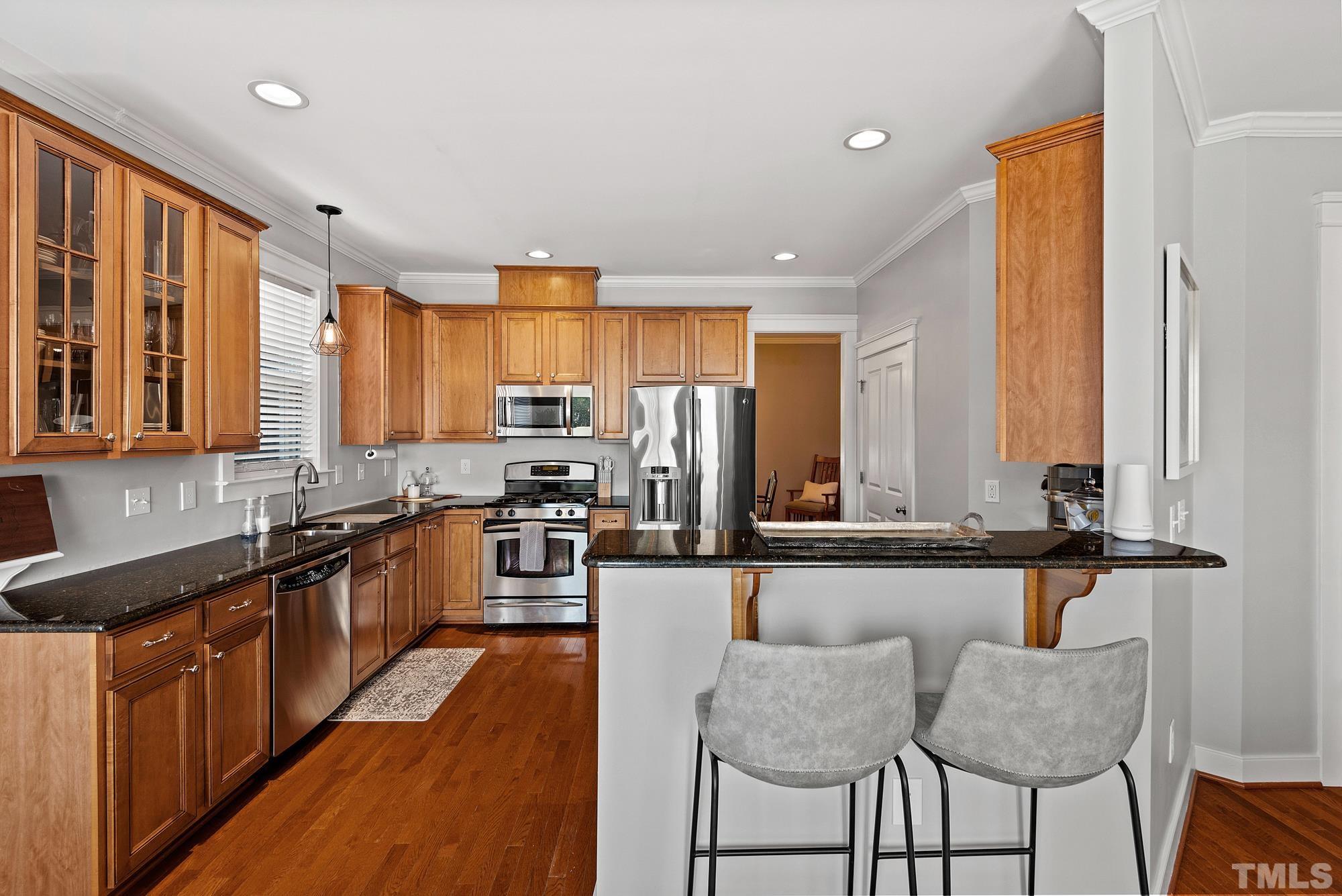4413 All Points View Way Raleigh, NC 27614 - Photo 14 of 51 a kitchen with stainless steel appliances granite countertop a stove top oven a sink dishwasher a dining table and chairs with wooden floor