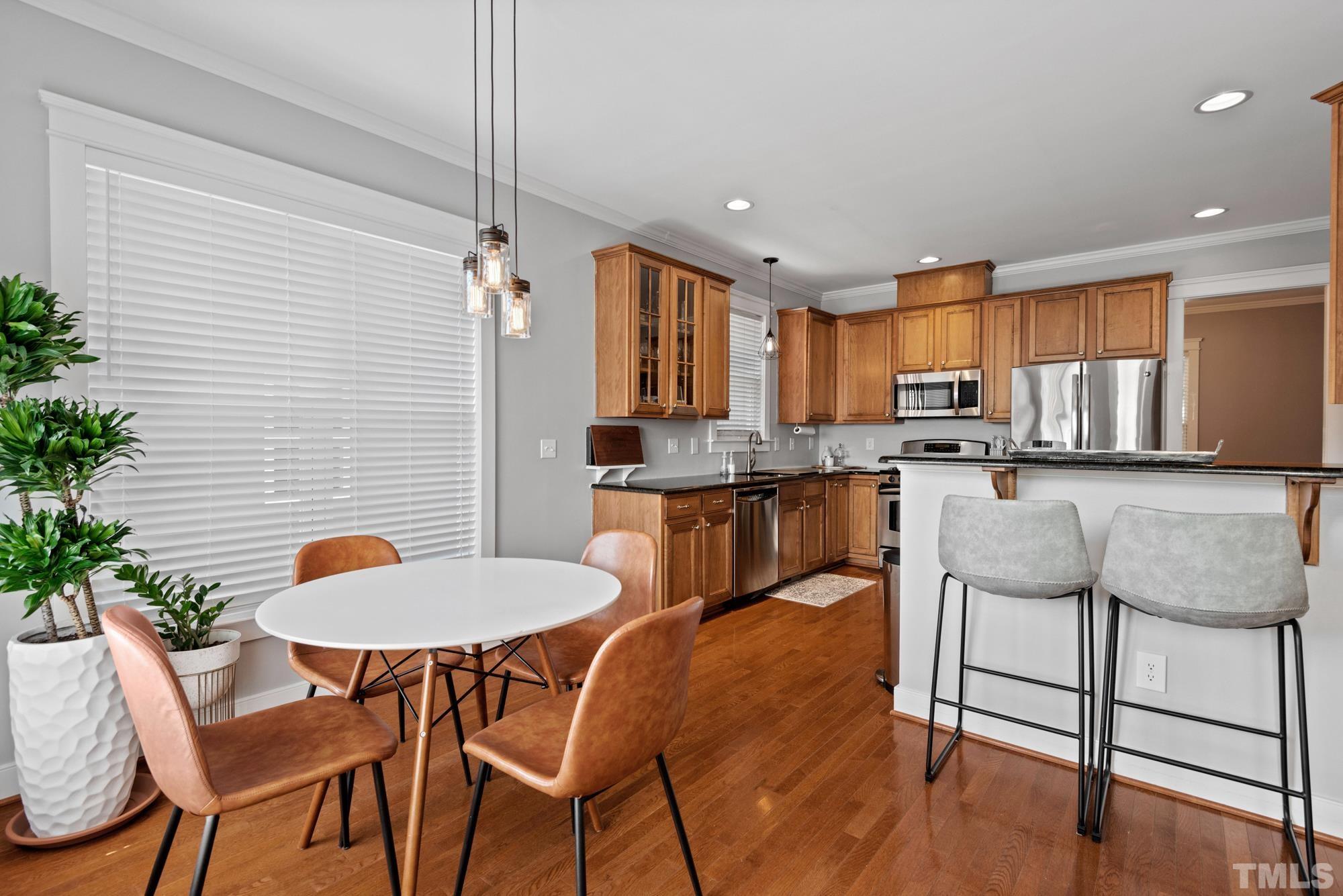 4413 All Points View Way Raleigh, NC 27614 - Photo 10 of 51 a kitchen with stainless steel appliances granite countertop a table chairs and a refrigerator