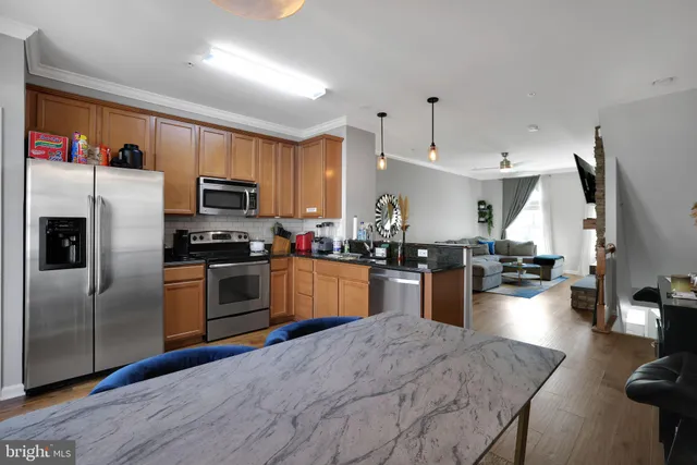 a kitchen with kitchen island a counter top space a sink stainless steel appliances and cabinets