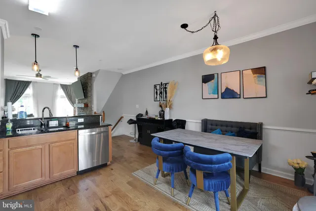 a kitchen with stainless steel appliances a table chairs and wooden floor