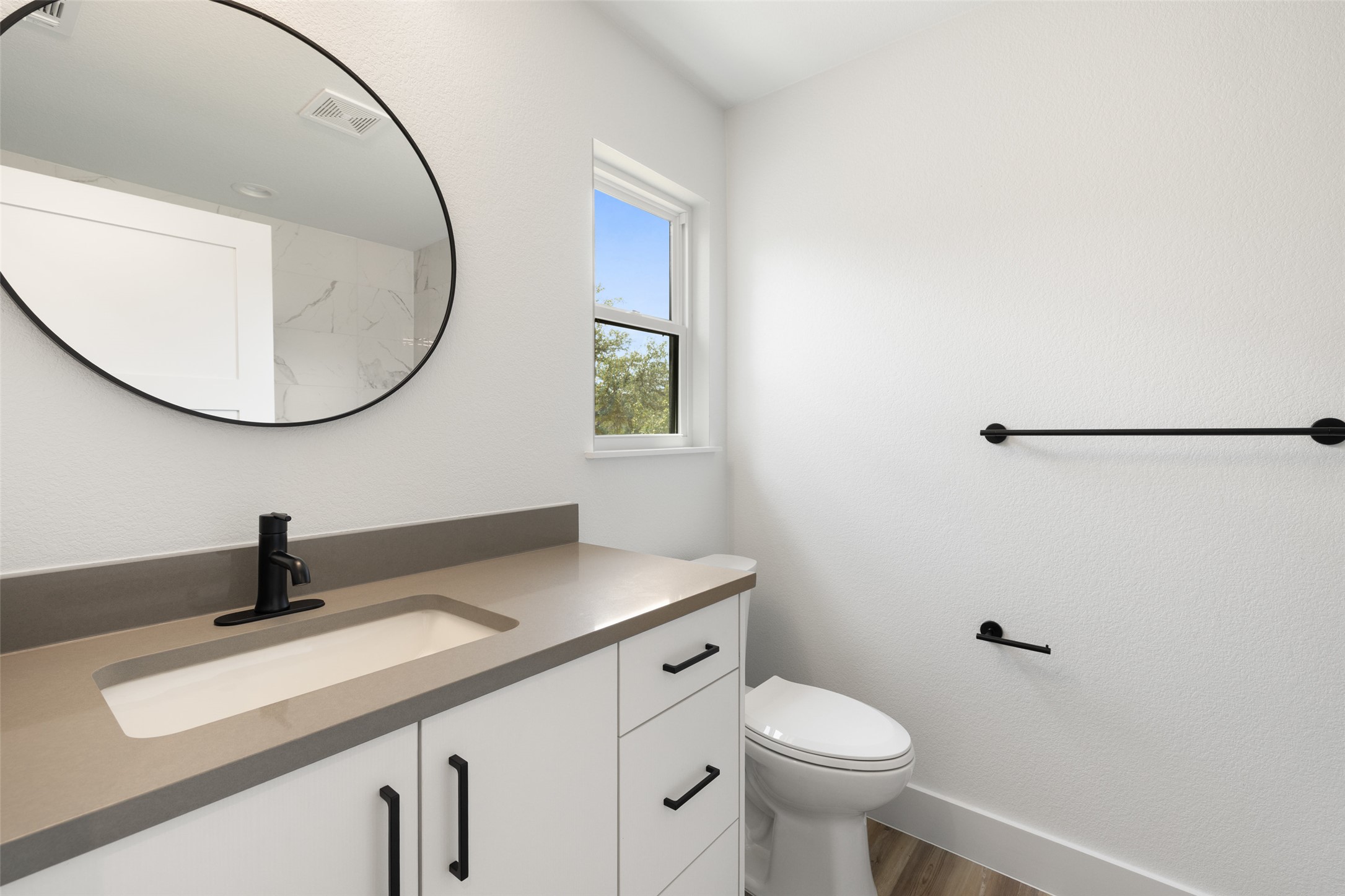 11151 Highway 71 Spicewood, TX 78669 - Photo 13 of 38 a bathroom with a sink a toilet and a mirror