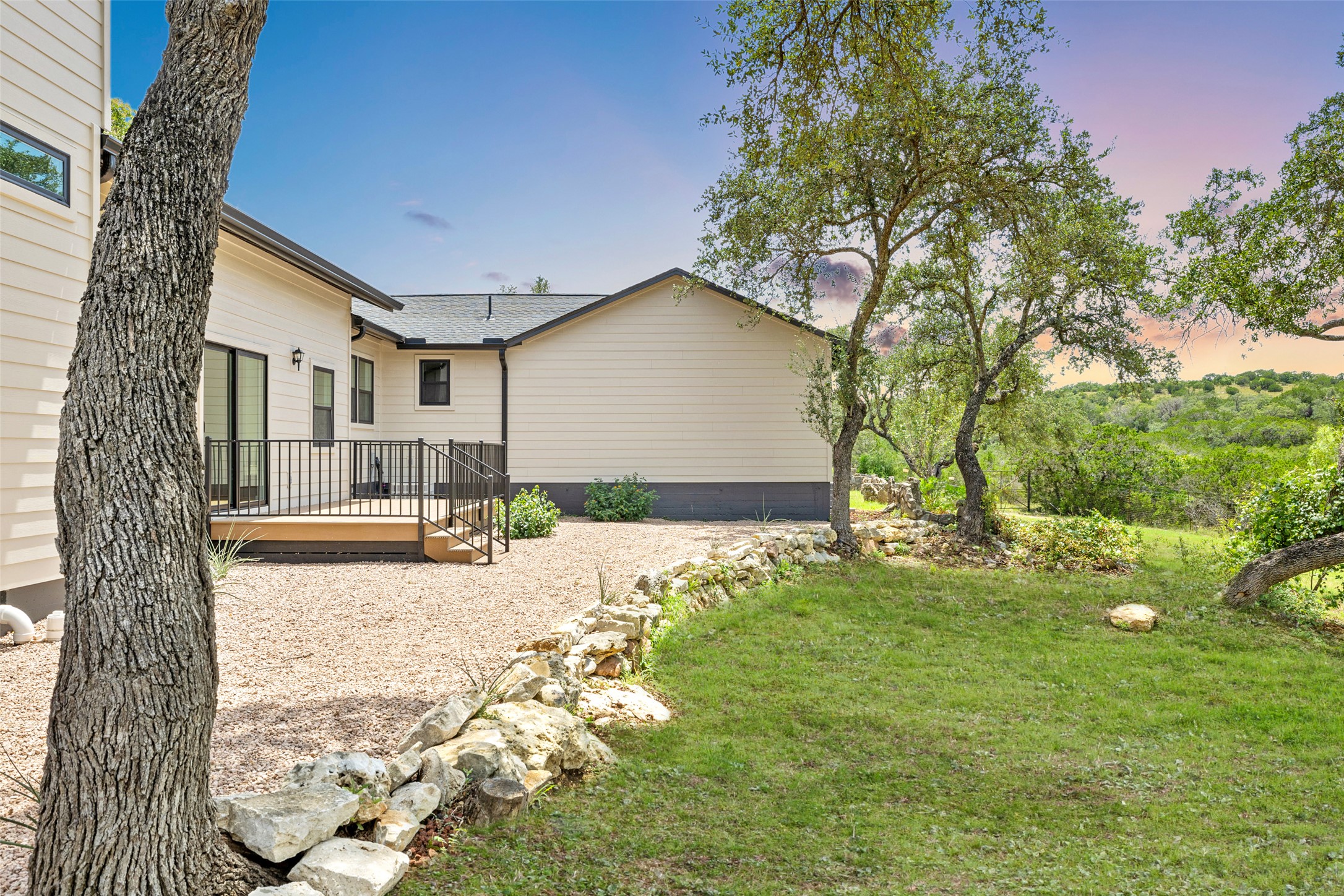 11151 Highway 71 Spicewood, TX 78669 - Photo 15 of 38 Backyard space of the First Residence - Yard at dusk featuring a wooden deck and a yard.