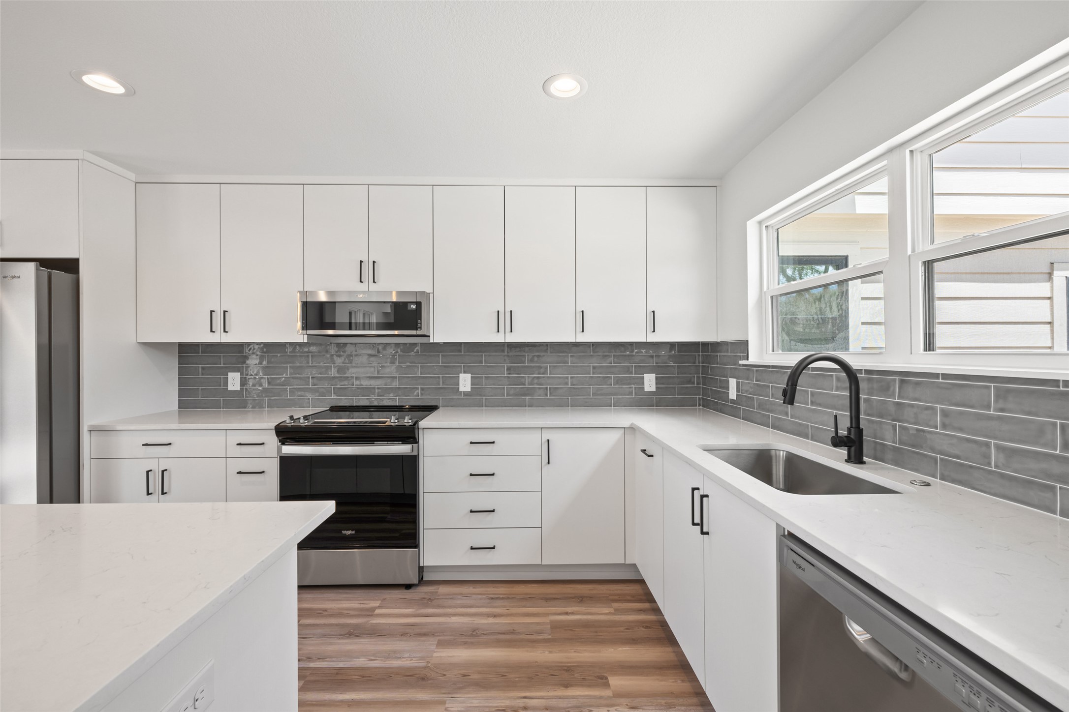 11151 Highway 71 Spicewood, TX 78669 - Photo 20 of 38 a kitchen with granite countertop white cabinets and white appliances