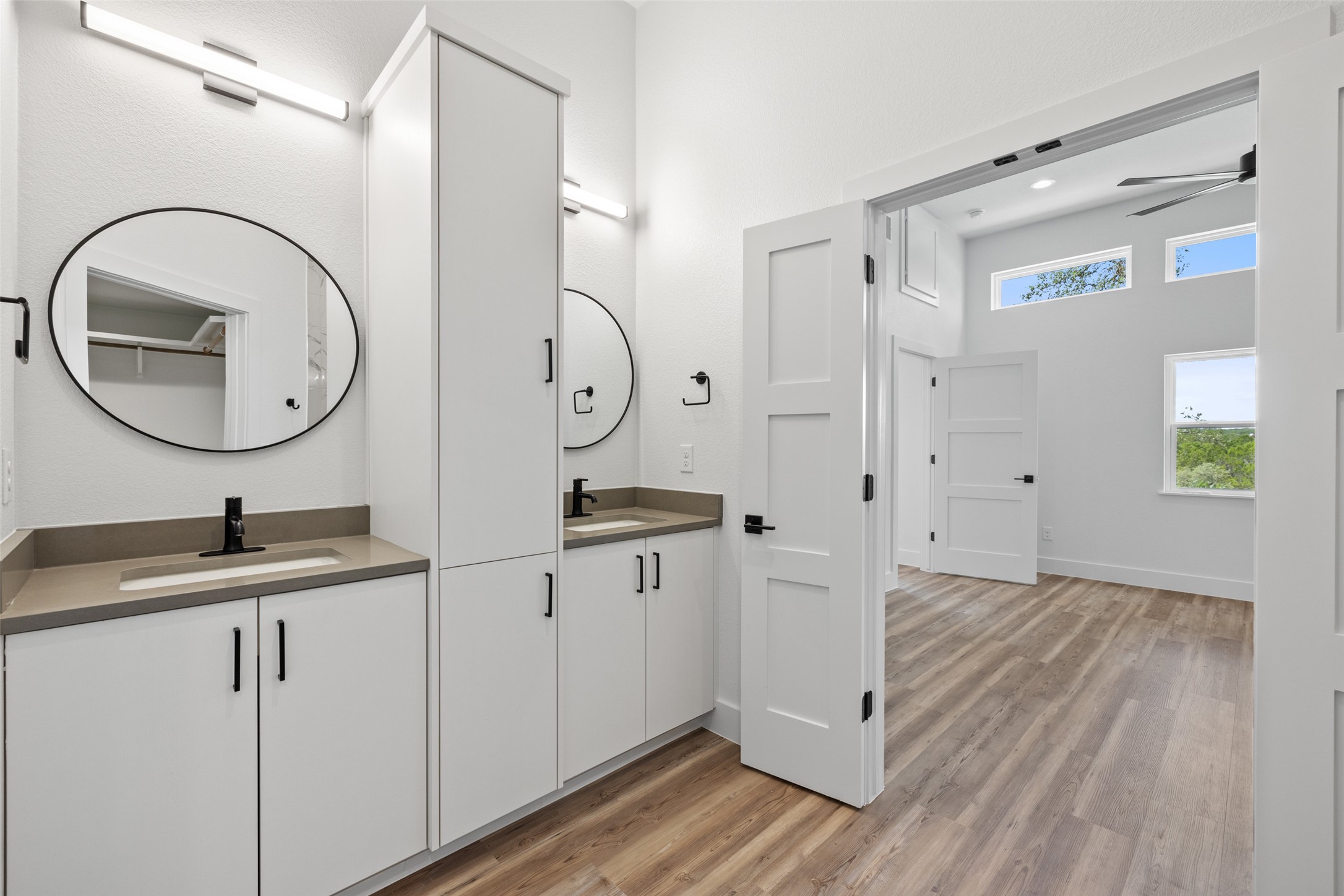 11151 Highway 71 Spicewood, TX 78669 - Photo 23 of 38 Middle Residence – Primary bathroom showcasing a vanity, ceiling fan, and light wood-style LVP flooring.