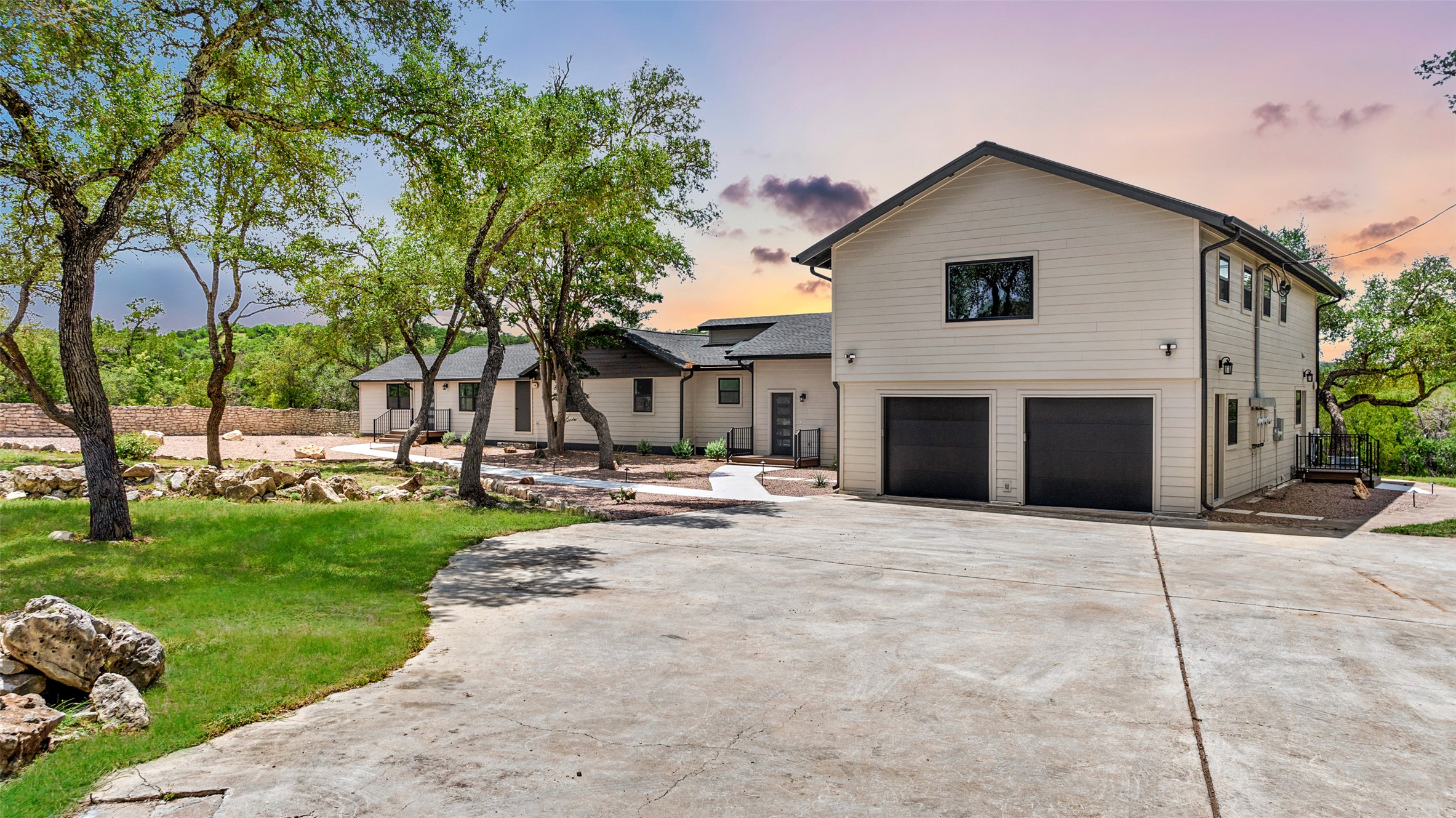 11151 Highway 71 Spicewood, TX 78669 - Photo 30 of 38 Third Residence - Front view of the estate highlighting the driveway, garage, and front yard, with the third residence located above the garage and accessed via a private side entrance.
