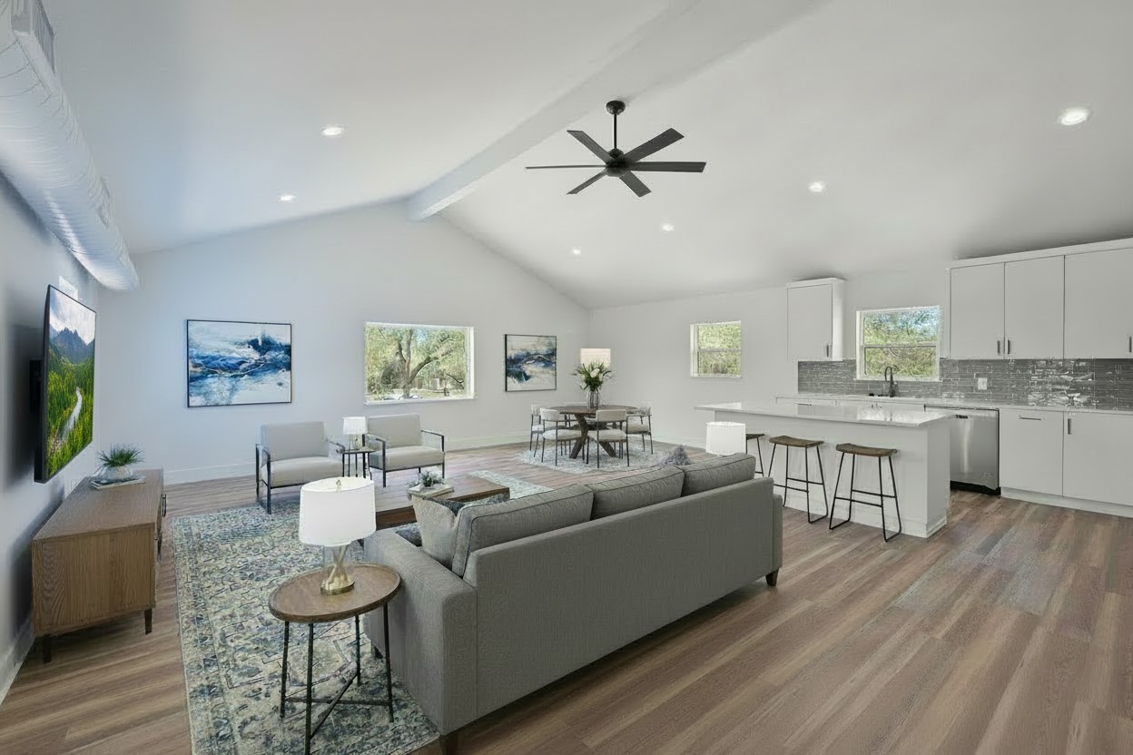 11151 Highway 71 Spicewood, TX 78669 - Photo 31 of 38 Third Residence – Open-concept living, dining, and kitchen showcasing a vaulted ceiling, white cabinetry, center island, light wood-style flooring, recessed lighting, and expansive second-floor Hill Country views. *Photo has been virtually staged.