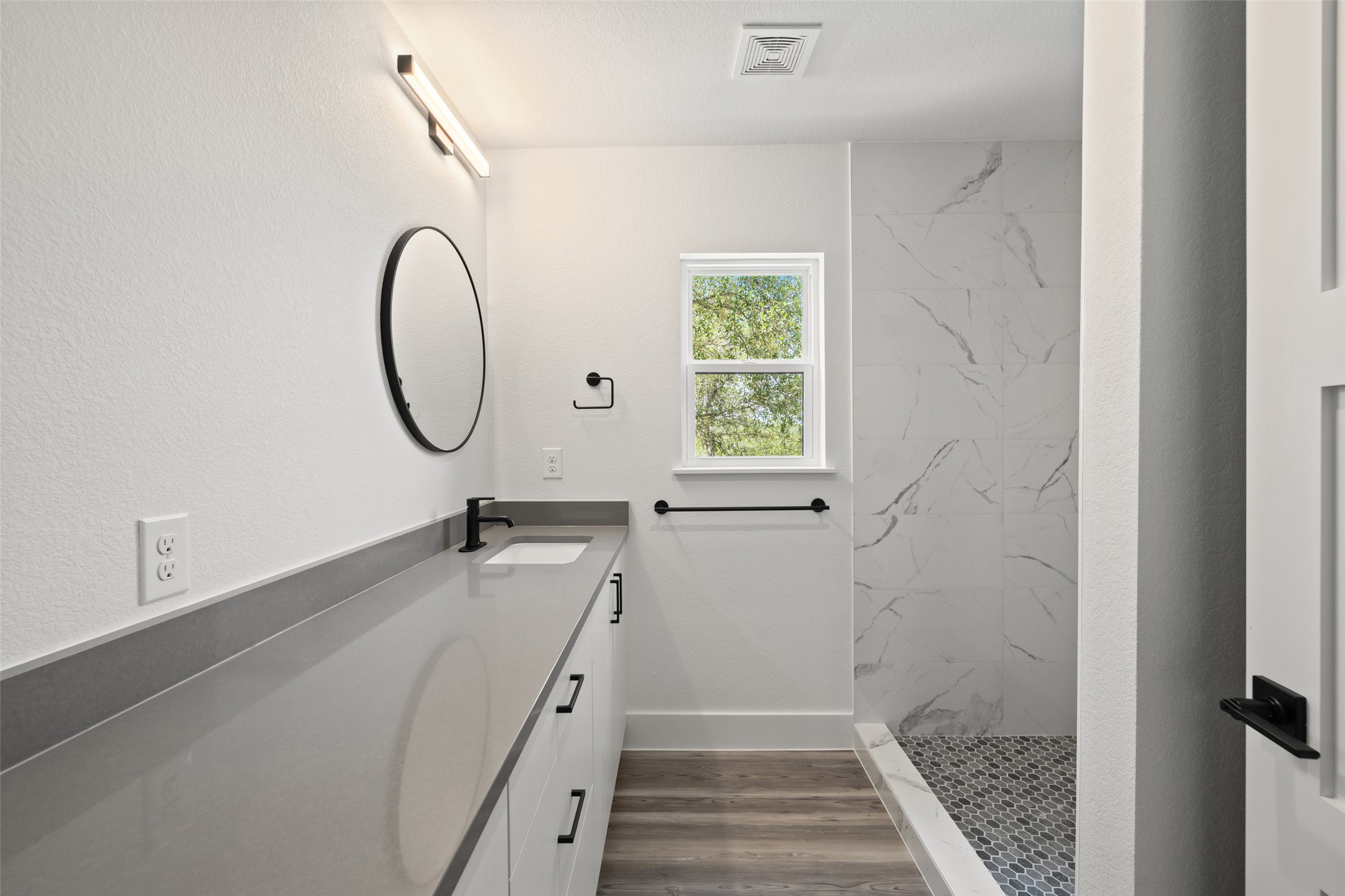 11151 Highway 71 Spicewood, TX 78669 - Photo 34 of 38 Third Residence – Full bathroom showcasing gray quartz countertops and a luxurious walk-in shower.