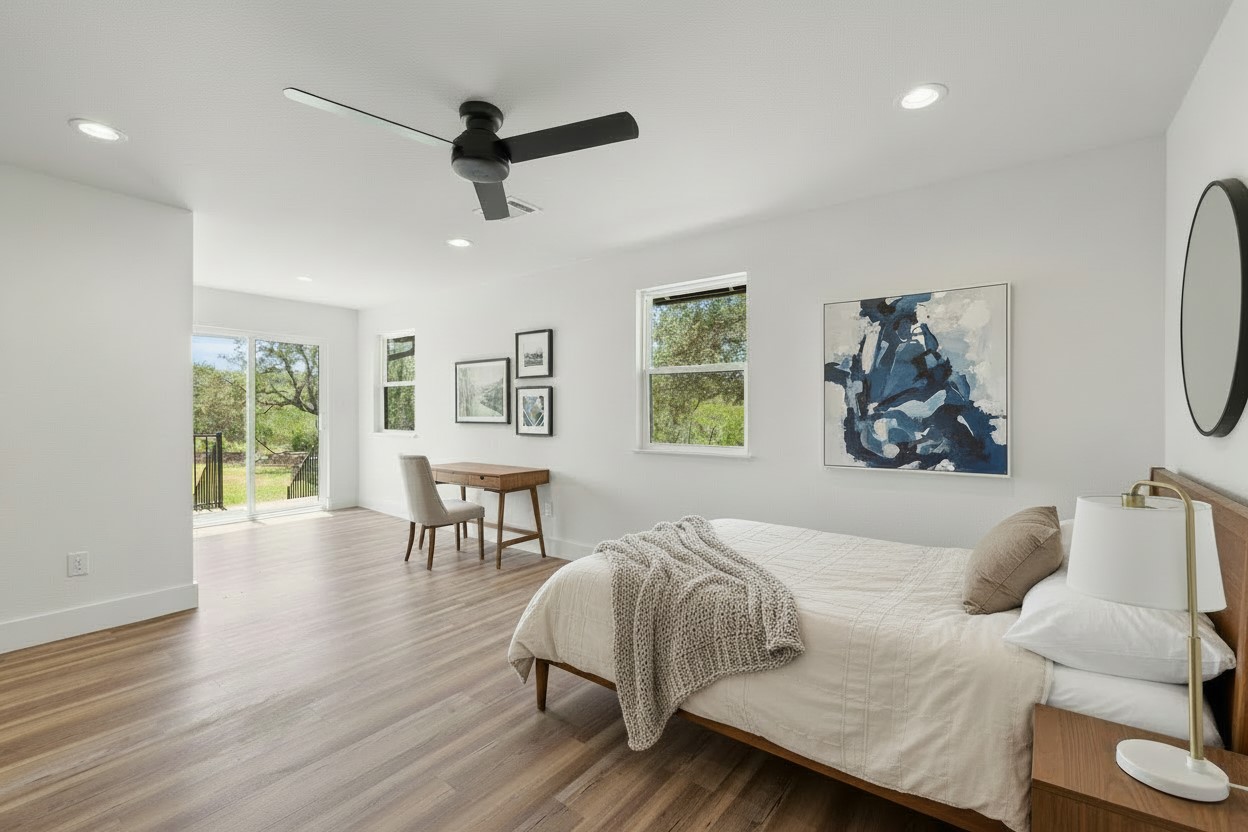 11151 Highway 71 Spicewood, TX 78669 - Photo 9 of 38 First Residence – Spacious primary bedroom with light wood-style LVP flooring and a private sitting area. *Photo has been virtually staged.