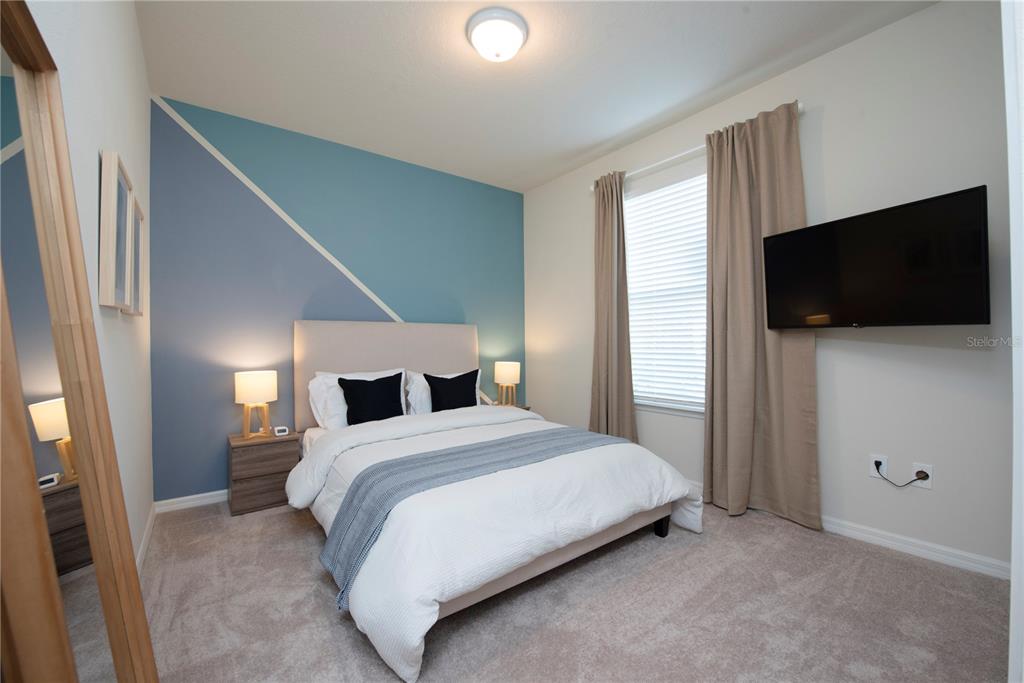 126 Jetty Way Davenport, FL 33897 - Photo 12 of 52 a bedroom with a bed and a flat screen tv