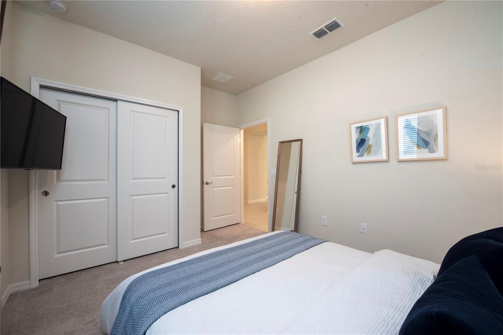126 Jetty Way Davenport, FL 33897 - Photo 14 of 52 a bedroom with a bed and a flat screen tv