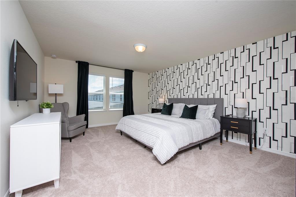 126 Jetty Way Davenport, FL 33897 - Photo 25 of 52 a spacious bedroom with a bed and a flat screen tv