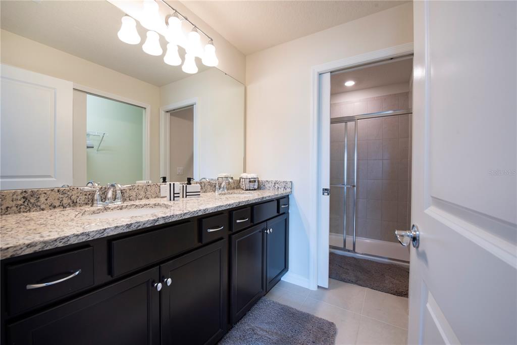 126 Jetty Way Davenport, FL 33897 - Photo 28 of 52 a bathroom with a granite countertop sink and a mirror