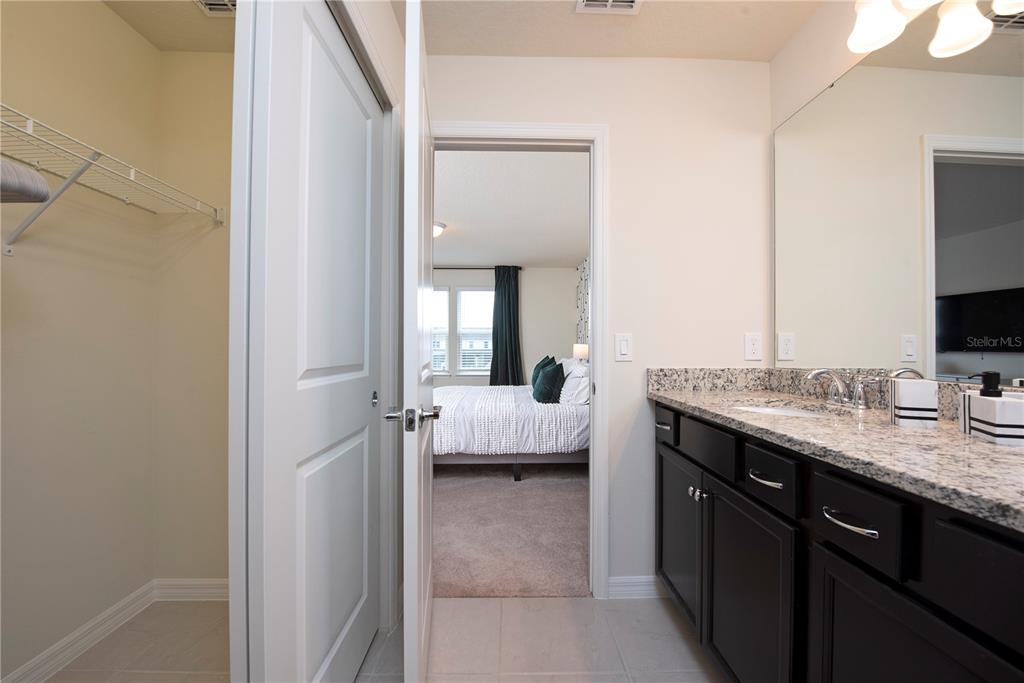 126 Jetty Way Davenport, FL 33897 - Photo 29 of 52 a en suite bathroom with a granite countertop sink and a mirror