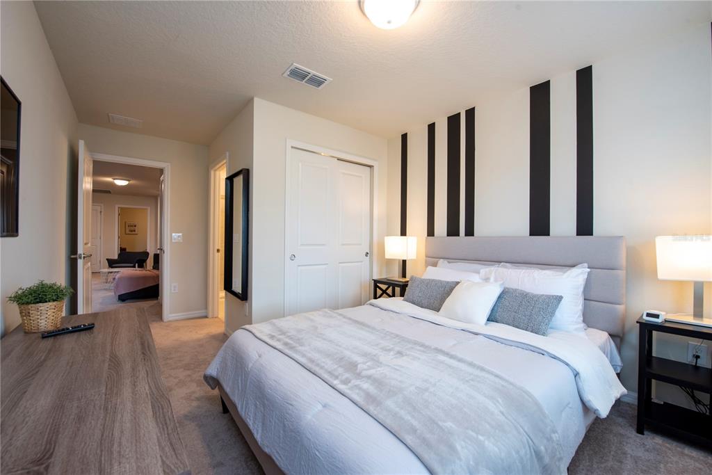 126 Jetty Way Davenport, FL 33897 - Photo 31 of 52 a bedroom with bed and a large mirror