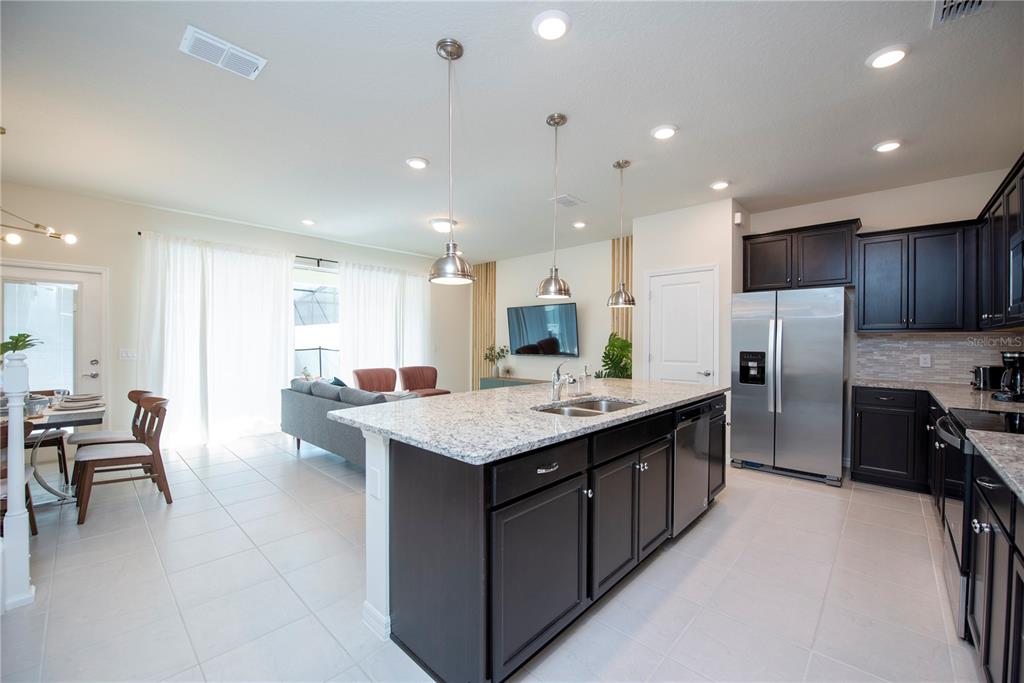 126 Jetty Way Davenport, FL 33897 - Photo 6 of 52 a kitchen with stainless steel appliances kitchen island granite countertop a large island in the center