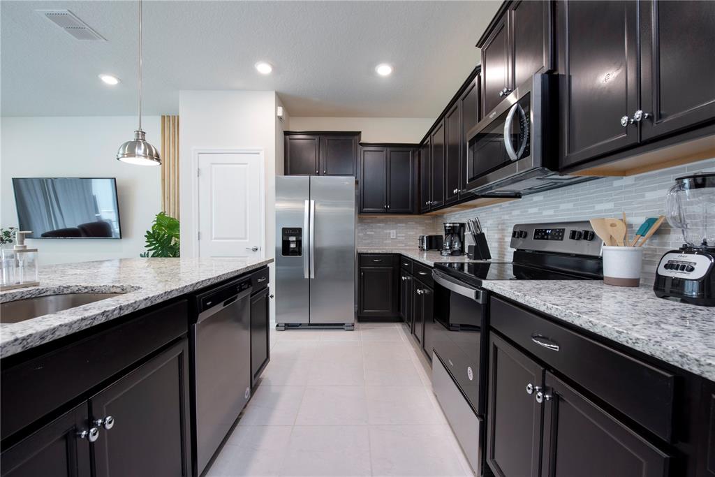 126 Jetty Way Davenport, FL 33897 - Photo 9 of 52 a kitchen with stainless steel appliances granite countertop counter space a sink and cabinets
