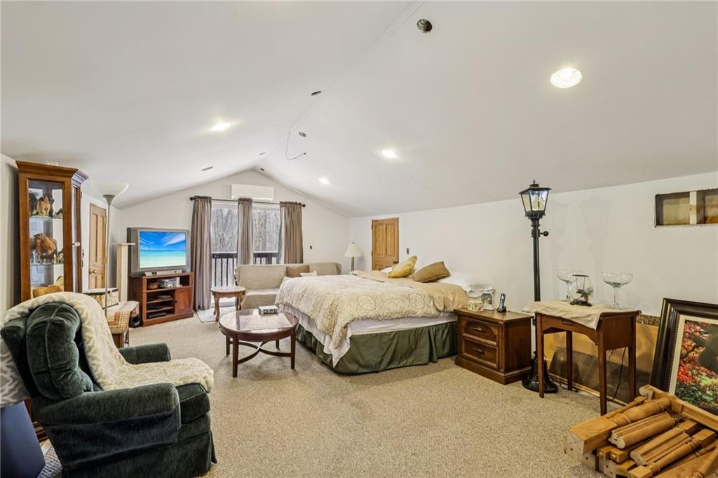 199 Anglers Rest Lane Utica, PA 16362 - Photo 25 of 49 a spacious bedroom with a bed a couch and a chandelier