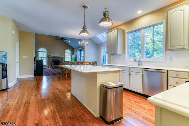 a kitchen with stainless steel appliances granite countertop wooden floors sink and cabinets