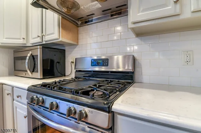 a stove top oven sitting inside of a kitchen
