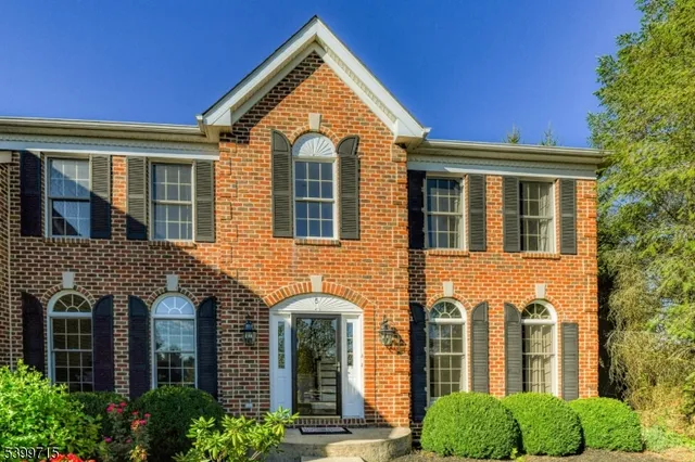 a view of a brick house with large windows and a large tree