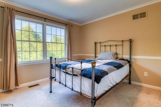 a bed sitting in a bedroom next to a window