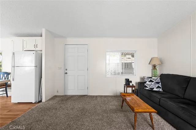 a living room with furniture a refrigerator and a dining table